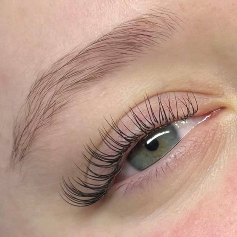 A natural, wispy classic lash set on a green eye.